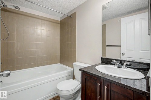 Bathroom featuring a vanity with dark wood-finish cabinetry and a dark countertop - 404 1080 Mcconachie Boulevard, Edmonton, AB 