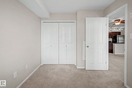 Neutral-toned walls and plush carpeting complement the white trim and doors - 404 1080 Mcconachie Boulevard, Edmonton, AB 