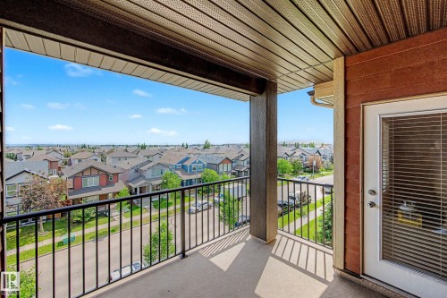 Spacious private balcony with concrete flooring and black metal railings - 404 1080 Mcconachie Boulevard, Edmonton, AB 