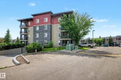 Multi-story residential building featuring a stone facade, red siding, and multiple balconies with dark railings - 