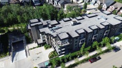 Contemporary multi-story building featuring multiple balconies, a flat roofline, and an integrated underground parking garage entrance - 