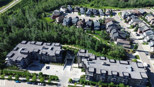 Contemporary multi-story residential buildings featuring balconies and a surrounding tree line - 211 5029 Edgemont Boulevard, Edmonton, AB 