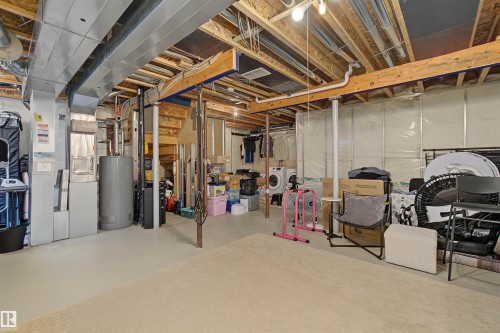 Unfinished basement featuring exposed ceiling joists, ductwork, and structural beams - 15 450 Hyndman Crescent, Edmonton, AB 