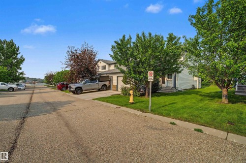 Two-story residence featuring a white siding exterior and an attached single-car garage - 15 450 Hyndman Crescent, Edmonton, AB 