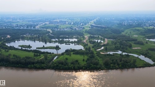Expansive natural landscape featuring a broad riverfront, multiple interconnected ponds, and abundant mature trees - 15 450 Hyndman Crescent, Edmonton, AB 