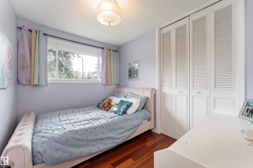 Hardwood flooring complements a double window with exterior foliage - 7816 142 Street, Edmonton, AB 