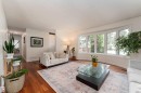 Spacious living area featuring wood-finish flooring, a large bay window, and a recessed ceiling - 7816 142 Street, Edmonton, AB 