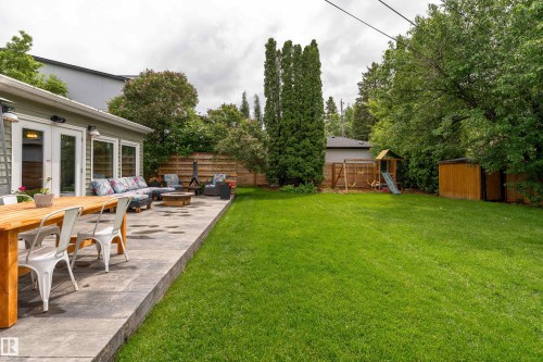 Expansive backyard featuring a manicured lawn and a concrete patio - 7816 142 Street, Edmonton, AB 