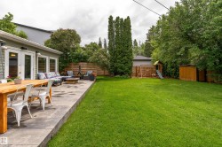 Expansive backyard featuring a manicured lawn and a concrete patio - 