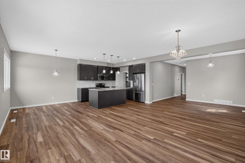 Open-concept living space featuring wood-finish flooring - 2460 15 Avenue, Edmonton, AB 