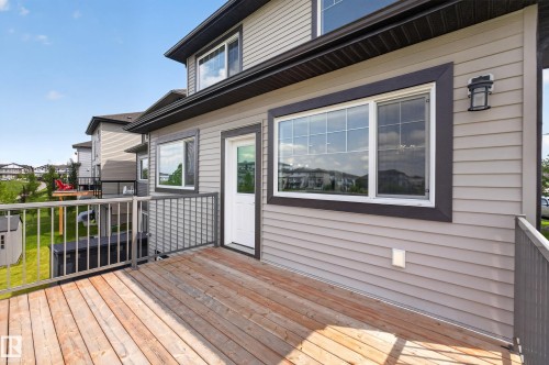 Rear wood-finish deck with metal railings and exterior siding - 2460 15 Avenue, Edmonton, AB 