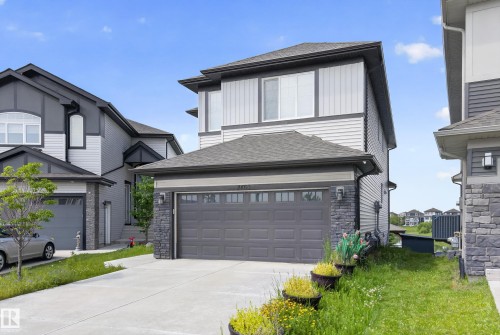 Modern two-story residence featuring a gray exterior with stone accents and horizontal siding - 2460 15 Avenue, Edmonton, AB 