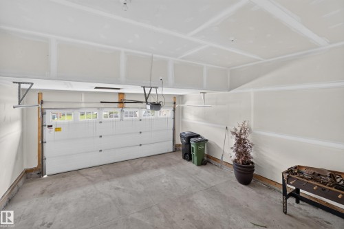 Attached two-car garage featuring a sectional garage door with upper window inserts and an automatic opener - 2460 15 Avenue, Edmonton, AB 