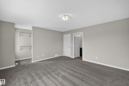 Spacious room featuring gray carpet, light gray painted walls, and white trim - 2460 15 Avenue, Edmonton, AB 