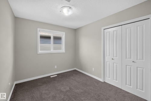 Neutral-toned walls complement the dark gray carpet flooring - 2460 15 Avenue, Edmonton, AB 