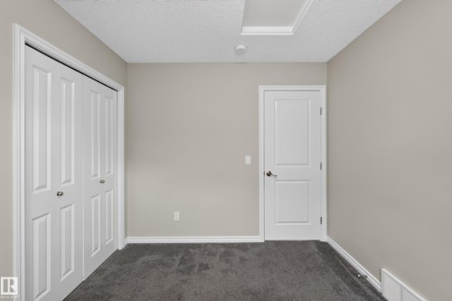 Neutral-toned interior room with gray carpet flooring - 2460 15 Avenue, Edmonton, AB 