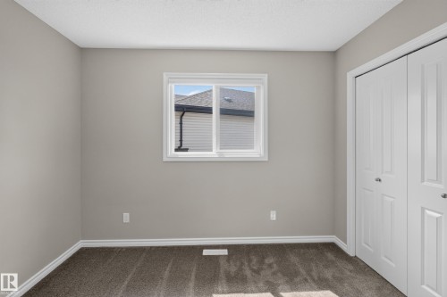 Neutral painted walls complement the textured carpet flooring - 2460 15 Avenue, Edmonton, AB 