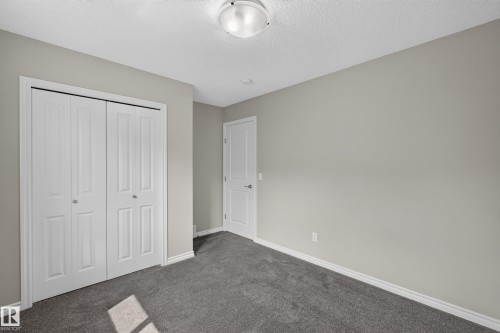 Interior room featuring neutral wall color, gray carpet, white baseboards, and a flush mount ceiling light - 2460 15 Avenue, Edmonton, AB 