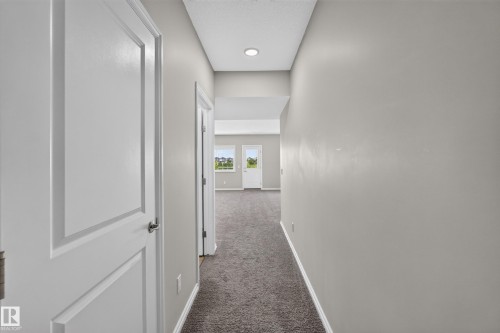 Hallway featuring recessed lighting, light gray wall paint, white baseboards, and gray carpet flooring - 2460 15 Avenue, Edmonton, AB 