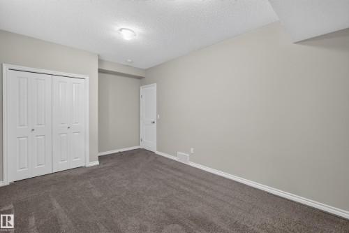 Room featuring neutral wall tones, gray carpeting, and white baseboards - 2460 15 Avenue, Edmonton, AB 