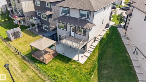 Rear exterior featuring a spacious elevated deck with metal railings, an outdoor gazebo with a solid roof, a storage shed, and a concrete patio - 2460 15 Avenue, Edmonton, AB 