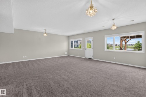 Spacious room featuring neutral carpeting and light gray walls - 2460 15 Avenue, Edmonton, AB 