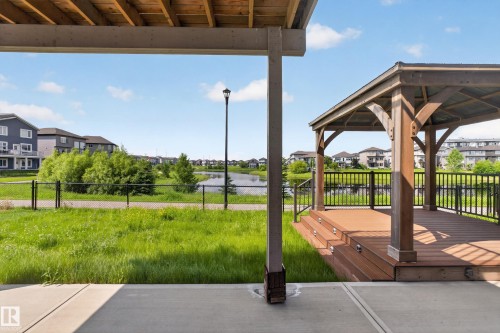 Spacious outdoor concrete patio with an adjacent elevated wood-finish gazebo featuring integrated step lighting and metal railings - 2460 15 Avenue, Edmonton, AB 