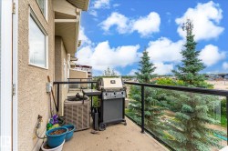 Exterior balcony featuring a stucco facade, glass panel railing, and concrete flooring - 