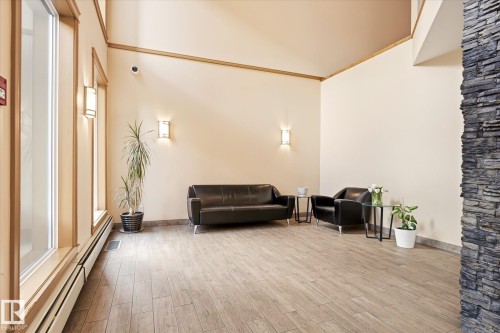 Spacious common area featuring wood-finish flooring and cream-colored walls - 402 10121 80 Avenue, Edmonton, AB 