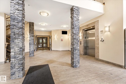Inviting lobby featuring stone-clad columns, tile flooring, and recessed ceiling lighting - 402 10121 80 Avenue, Edmonton, AB 