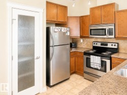 Kitchen featuring wood-finish cabinetry, stainless steel appliances, and a tiled backsplash - 