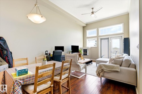 Expansive living space featuring wood-finish flooring, vaulted ceilings, and a contemporary ceiling fan - 402 10121 80 Avenue, Edmonton, AB 