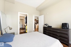Bedroom featuring light neutral wall tones and dark wood-finish flooring - 
