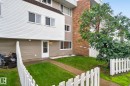 Townhome exterior featuring white siding and a brick facade - 401 2908 116A Avenue, Edmonton, AB 