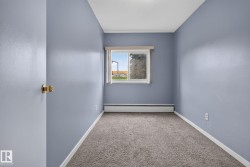 Carpeted interior room featuring light blue walls, white trim, and a window with a valance - 