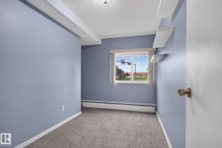 Room with light blue walls, gray carpet, white trim, and a window featuring white horizontal blinds - 