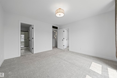 Spacious room featuring light gray carpet, white walls, and a contemporary flush-mount ceiling light - 2953 Coughlan Green Green, Edmonton, AB 
