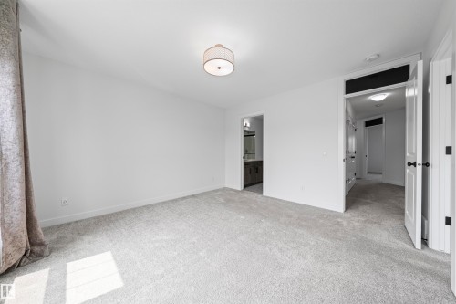Spacious room featuring light gray carpeting, neutral wall finishes, and a contemporary flush-mount ceiling light fixture - 2953 Coughlan Green Green, Edmonton, AB 