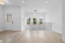 Foyer featuring light wood-finish flooring, a contemporary multi-bulb pendant light fixture, recessed ceiling lights, and white trim - 2953 Coughlan Green Green, Edmonton, AB 