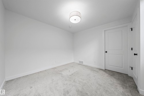 Neutral-toned carpeting paired with white walls, baseboards, and trim - 2953 Coughlan Green Green, Edmonton, AB 