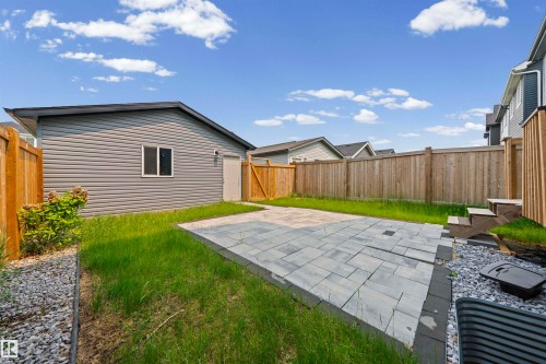 Spacious backyard featuring a large paver patio, wood fencing, and a detached structure with siding - 2953 Coughlan Green Green, Edmonton, AB 