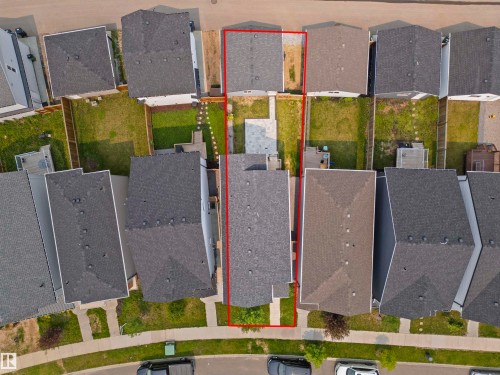 Aerial perspective of a residential property featuring a dark shingle roof, a front yard with green space and a concrete walkway, and a rear yard with a patio area and additional green space - 2953 Coughlan Green Green, Edmonton, AB 