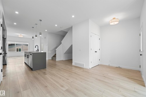 Contemporary open-concept living space with light wood-finish flooring - 2953 Coughlan Green Green, Edmonton, AB 