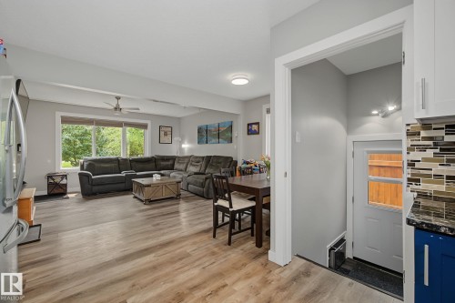 Open-concept living area featuring wood-finish flooring, a large picture window, and a ceiling fan - 3622 115 Avenue, Edmonton, AB 
