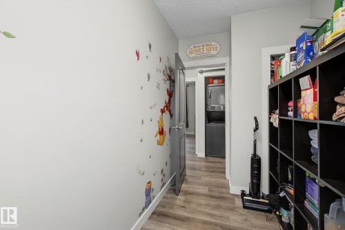 Hallway featuring wood-finish flooring, light grey walls, and white baseboards - 3622 115 Avenue, Edmonton, AB 