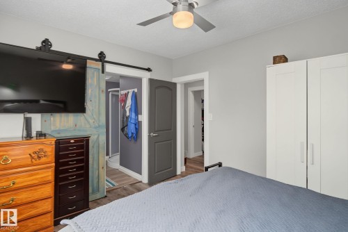 Bedroom featuring gray wall paint, wood-finish flooring, and a ceiling fan with integrated lighting - 3622 115 Avenue, Edmonton, AB 