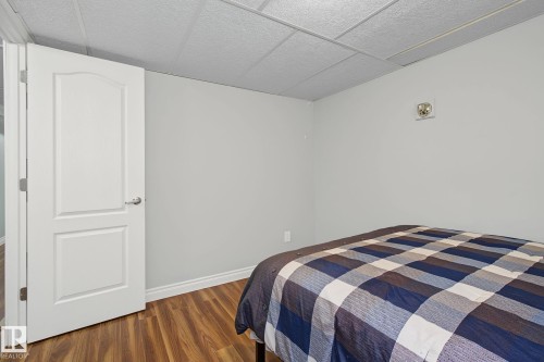 Bedroom featuring wood-finish flooring, light gray wall paint, and white trim - 3622 115 Avenue, Edmonton, AB 