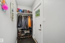 Entryway featuring a white paneled door with glass inserts, a built-in closet with hanging rod and upper shelf, and light gray wall paint - 3622 115 Avenue, Edmonton, AB 