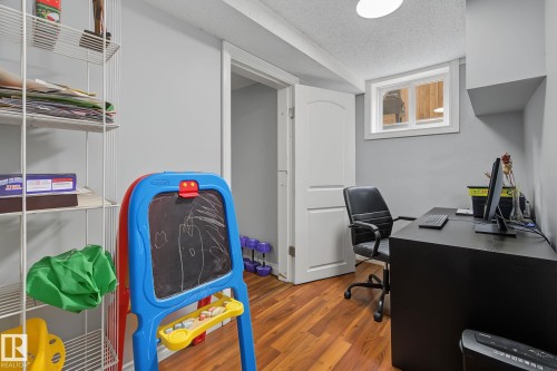 Versatile room featuring wood-finish flooring and a window providing natural light - 3622 115 Avenue, Edmonton, AB 