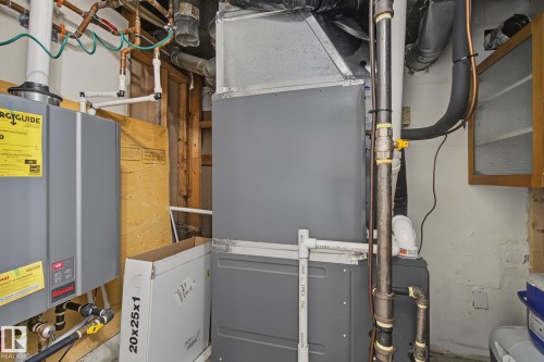 Utility area featuring a furnace system, water heater, and exposed copper piping - 3622 115 Avenue, Edmonton, AB 